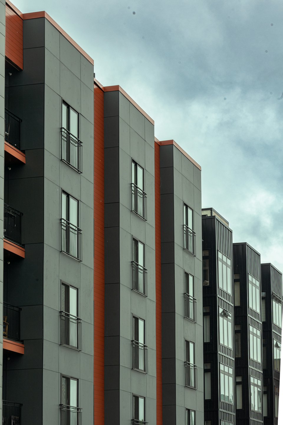 Moderno condominio residenziale con accenti in cotto e balconi in metallo.
